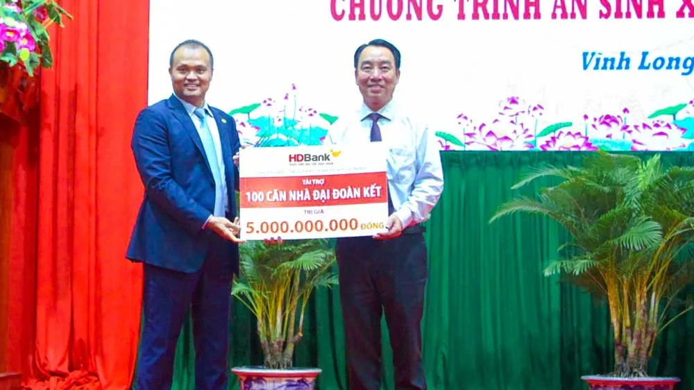 Ông Nguyễn Đăng Thanh – Phó Tổng Giám đốc HDBank (trái) trao tặng kinh phí xây dựng 100 căn nhà đại đoàn kết, ông Lữ Quang Ngời - Chủ tịch UBND tỉnh Vĩnh Long đại diện nhận