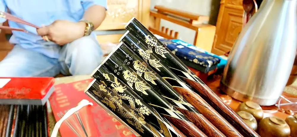 Sản phẩm của Lê Thanh Triển phong phú, đa dạng, đưa các hình ảnh con rồng, cá chép, chim hạc... lên cây đũa. Ảnh: MINH PHONG