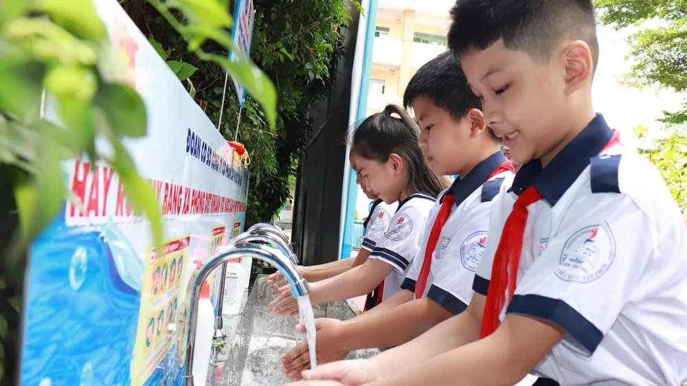 Niềm vui của các em học sinh khi được sử dụng nước sạch. Ảnh: ĐINH BÍCH