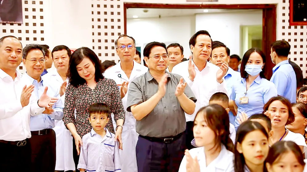 Thủ tướng Phạm Minh Chính và lãnh đạo các bộ, ngành thăm bệnh nhi đang điều trị tại Viện Huyết học và Truyền máu Trung ương. Ảnh: TTXVN