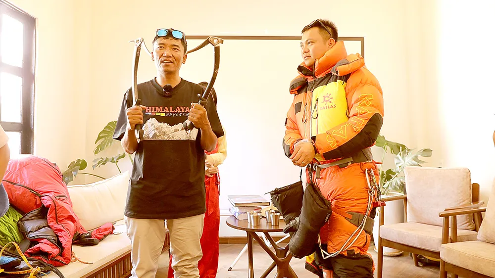 Anh Temba Bhote (bên trái) - người 10 lần chinh phục đỉnh Everest hướng dẫn cách mặc trang phục chuyên dùng khi leo núi tuyết cho bạn trẻ tham dự buổi giao lưu