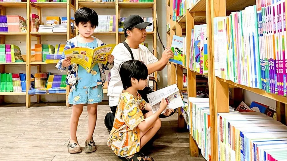 Phụ huynh cùng con tìm kiếm sách giáo khoa trước thềm năm học mới tại Nhà sách Phương Nam (phường Cầu Ông Lãnh, TPHCM) (ẢNH: HOÀNG HÙNG)