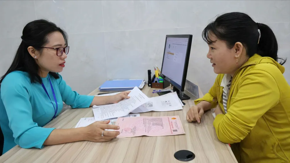 Chuyên viên pháp lý tại Văn phòng công chứng Nguyễn Thị Hồng Nhung (phường Dĩ An, TPHCM) hỗ trợ giải quyết thủ tục hành chính cho người dân (ẢNH: LÊ THOA)