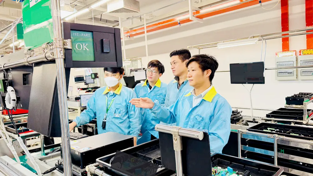 Anh Võ Anh Tuấn (bìa phải) cùng đồng nghiệp kiểm tra các bộ phận công nghệ tại Công ty TNHH Jabil Việt Nam. ẢNH: NVCC