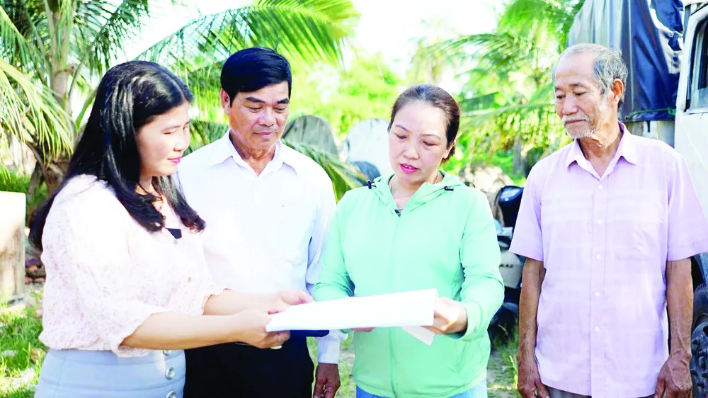 Đại diện Hội Liên hiệp Phụ nữ xã Hòa Vang (TP Đà Nẵng) vận động người dân thôn Cẩm Toại Trung giải phóng mặt bằng phục vụ dự án cải tạo, nâng cấp quốc lộ 14B (ẢNH: XUÂN QUỲNH)
