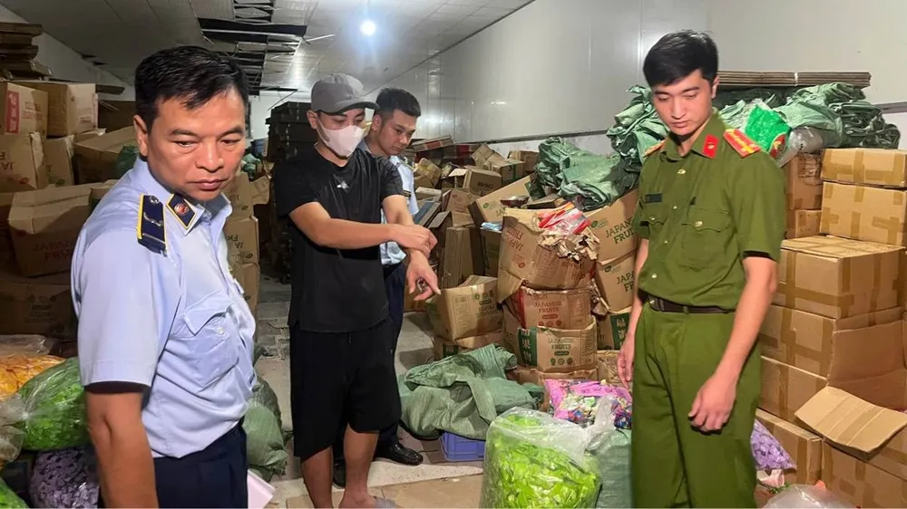Bị can Nguyễn Quang Đạt (đeo khẩu trang) tại kho hàng. Ảnh: CÔNG AN CUNG CẤP