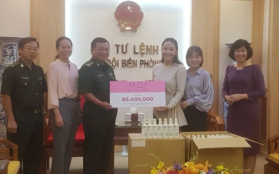 Đại diện Công ty Mỹ phẩm thương hiệu Việt M.O.I Cosmetics trao bảng tượng trưng số tiền tặng Bộ đội biên phòng