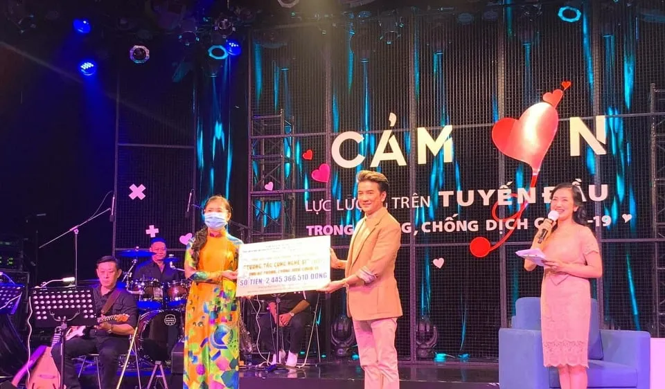 Ca sĩ Đàm Vĩnh Hưng (phải) trao số tiền hơn 2 tỷ đồng vận động đóng góp từ chương trình "Tương tác cùng nghệ sĩ" ủng hộ phòng, chống dịch Covid-19