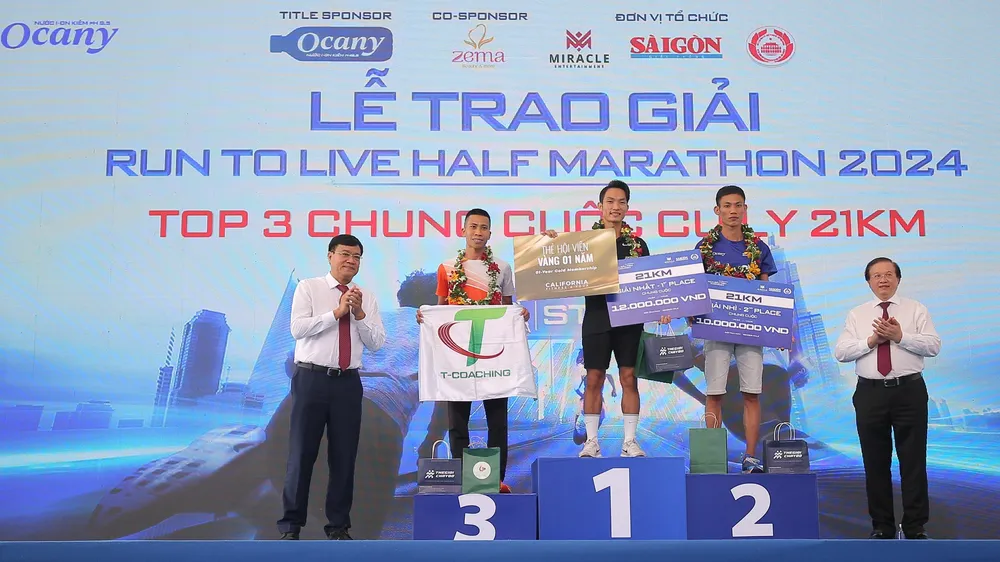Thứ trưởng Bộ VH-TT-DL Tạ Quang Đông (phải) và Cục trưởng Cục TDTT Đặng Hà Việt trao giải cho các VĐV nội dung 21km nam. Ảnh: DŨNG PHƯƠNG 
