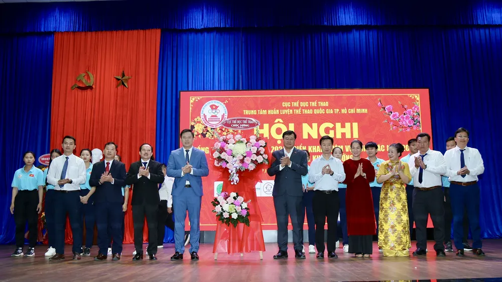 Cục trưởng Cục TDTT Đặng Hà Việt trao hoa chúc mừng Trung tâm HLTTQG TPHCM. Ảnh: DŨNG PHƯƠNG 