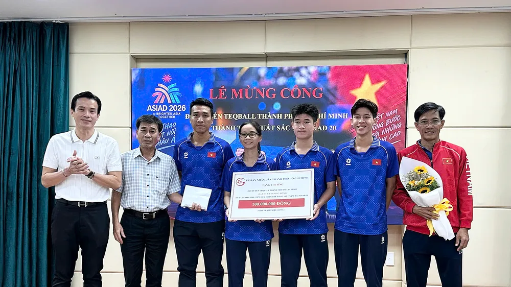 Phó Giám đốc Sở VH-TT TPHCM Nguyễn Nam Nhân (trái) trao 100 triệu đồng, phần thưởng từ UBND TPHCM cho thành viên đội tuyển teqball. Ảnh: THANH TÙNG 
