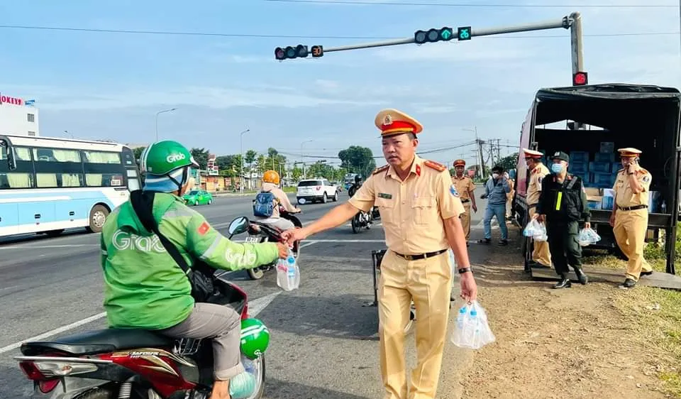Đồng Nai: Cảnh sát giao thông phát nón bảo hiểm và nước cho người dân về quê ăn tết