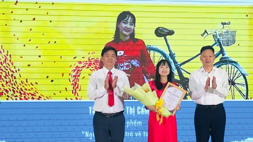 Phó Trưởng ban Tuyên giáo và Dân vận Thành ủy TPHCM Lê Văn Minh, trao giấy chứng nhận cho tác giả đoạt giải nhì.
