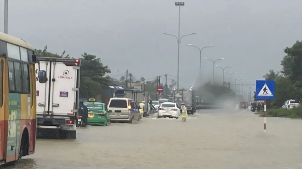 Nước ngập sâu một đoạn gần 100m trên tuyến Quốc lộ 1A tại huyện Phú Ninh (tỉnh Quảng Nam) khiến giao thông gặp khó khăn. Ảnh: NGUYỄN CƯỜNG