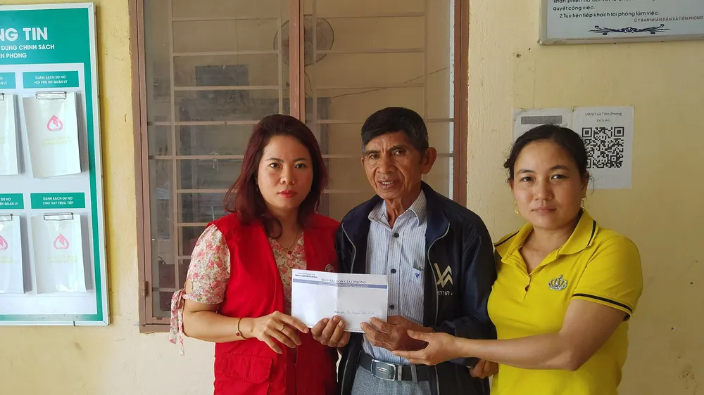 Đại diện xã Tiên Phong trao tiền của bạn đọc báo SGGP hỗ trợ cho gia đình ông Nguyễn Văn Miết