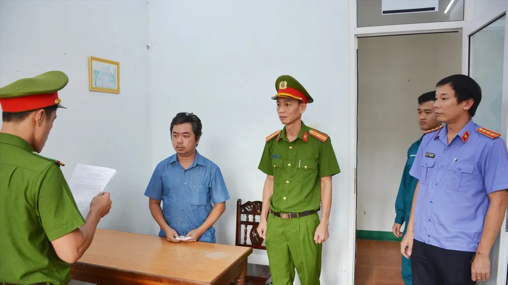 Lực lượng công an tống đạt quyết định tạm giam đối với Nguyễn Hoàng Minh. Ảnh M.T.