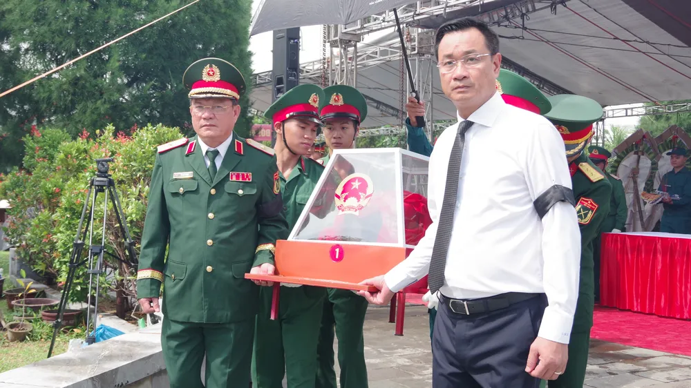 Bí thư Thành ủy Đà Nẵng Lê Ngọc Quang cùng lãnh đạo Bộ Tư lệnh Quân khu 5 thực hiện nghi thức an táng hài cốt liệt sĩ. Ảnh: QUANG CƯỜNG