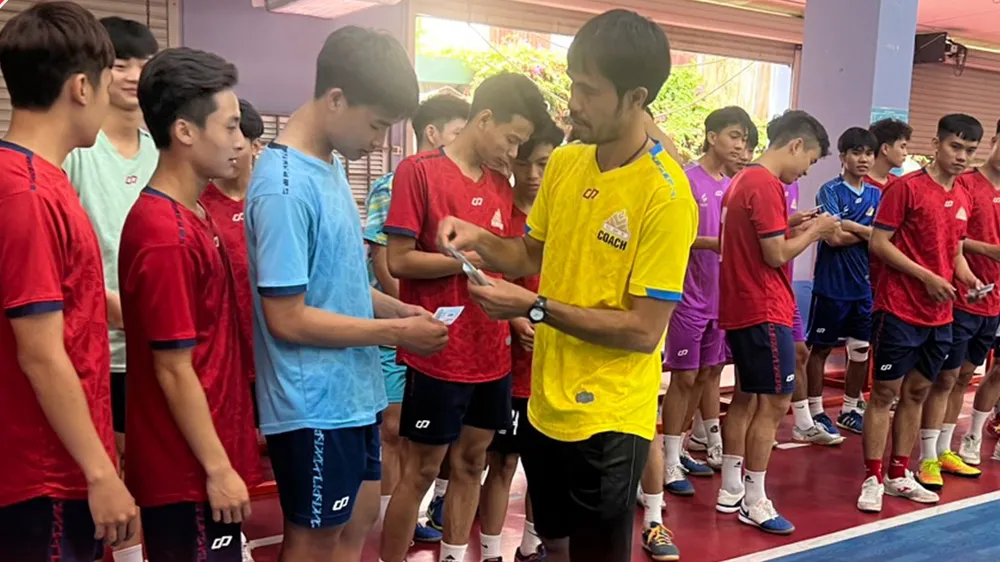 HLV Phạm Minh Giang lì xì đầu năm đến các học trò mới ở Cao Bằng. ẢNH: CLB 
