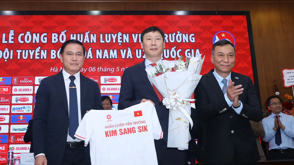 Chủ tịch VFF Trần Quốc Tuấn cùng Phó Chủ tịch VFF Trần Anh Tú tặng hoa chúc mừng đến tân HLV trưởng của ĐTQG Việt Nam Kim Sang-sik. ẢNH: MINH HOÀNG 