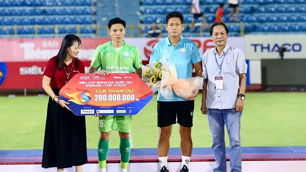 Trợ lý HLV Bùi Quang Huy cùng đội trưởng Trần Nguyên Mạnh của Nam Định buồn bã lên nhận bảng danh vị khi dự trận Siêu Cúp quốc gia 2024-2025. ẢNH: MINH HOÀNG 