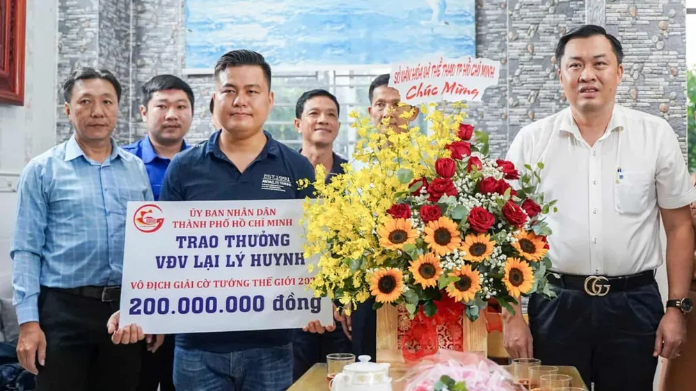 Ông Cao Văn Chóng, Phó Giám đốc Sở Văn hóa và Thể thao TPHCM, thừa ủy quyền Ủy ban Nhân dân TPHCM trao 200 triệu đồng tiền thưởng cho kỳ vương Lại Lý Huynh. ẢNH: TÂM HÀ 