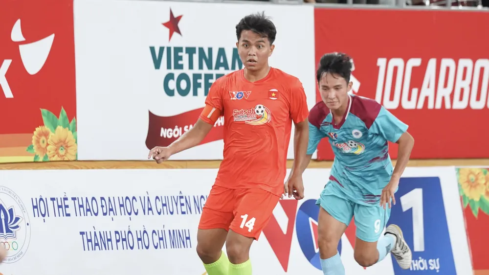 Trận đấu khai mạc giữa 2 đội futsal đến từ Trường Đại học Nông Lâm (áo cam) và Trường Đại học Ngoại ngữ - Tin học (áo xanh). ẢNH: TÂM HÀ