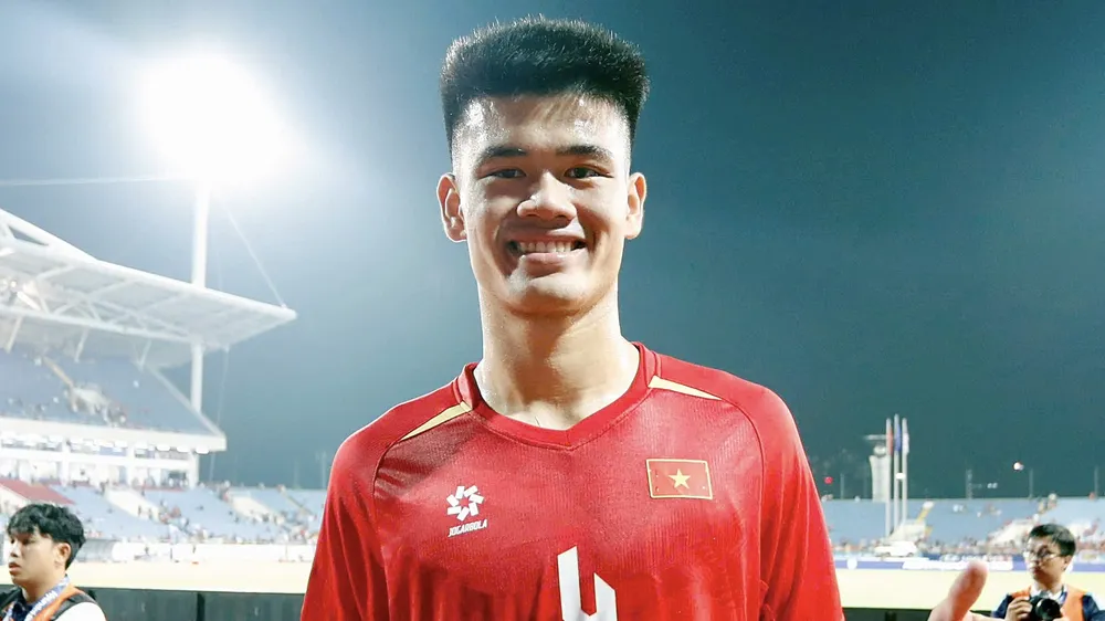 Tuyển thủ Đinh Quang Kiệt vinh dự khi được cầm cờ Việt Nam tại lễ khai mạc ASIAD 2026. ẢNH: ANH KHOA 