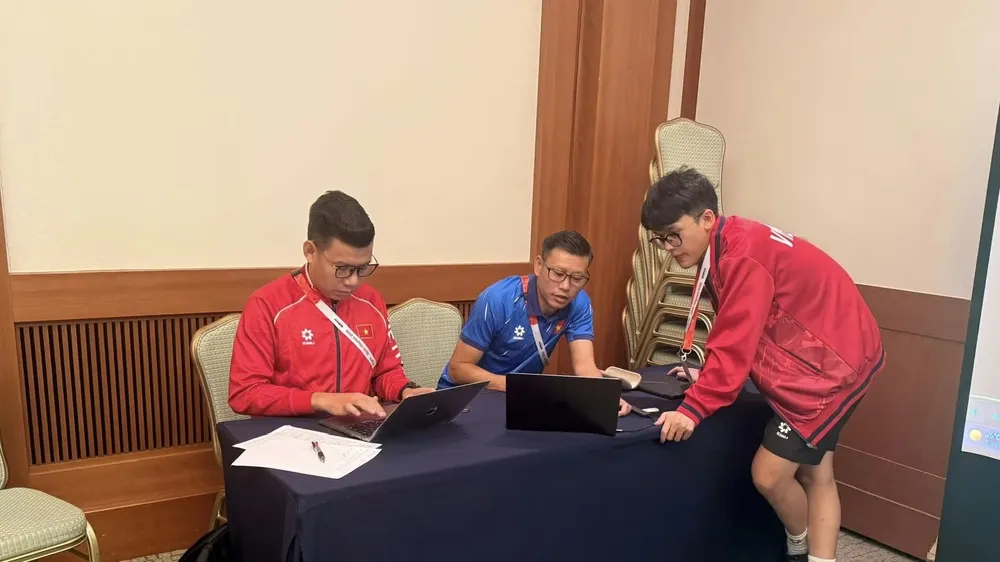 Trợ lý HLV Thạch Bảo Khanh (áo xanh) cùng các cộng sự lên băng ghi hình đối thủ cho U23 Việt Nam nghiên cứu. ẢNH: NVCC