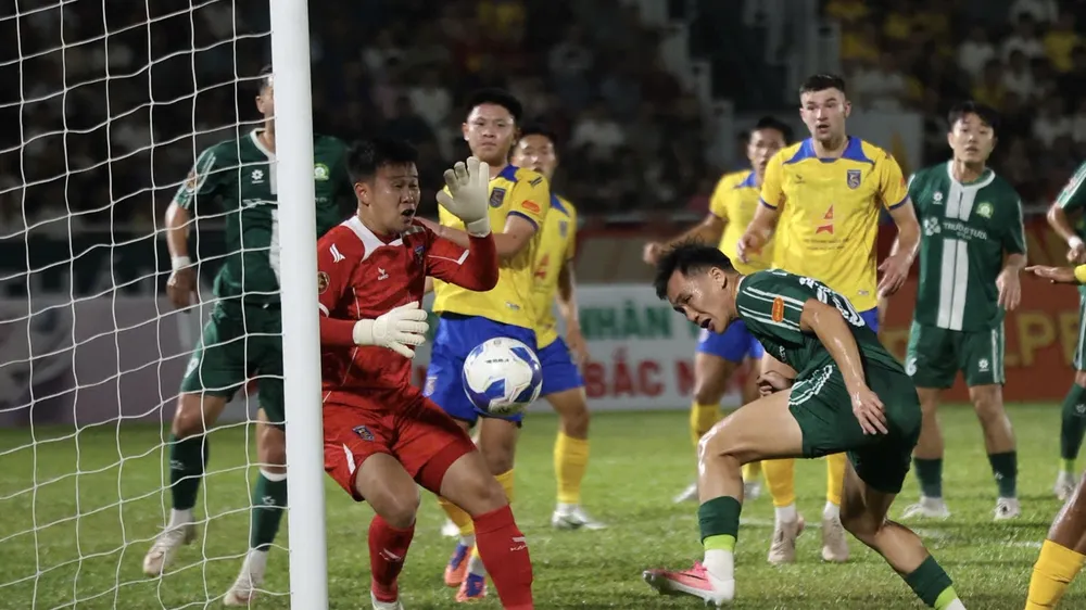 Tiền đạo Lưu Tự Nhân (áo xanh, Bình Phước) đánh đầu đưa bóng dội cột dọc Bắc Ninh ở khoảng cách 2m. ẢNH: TÂM HÀ 