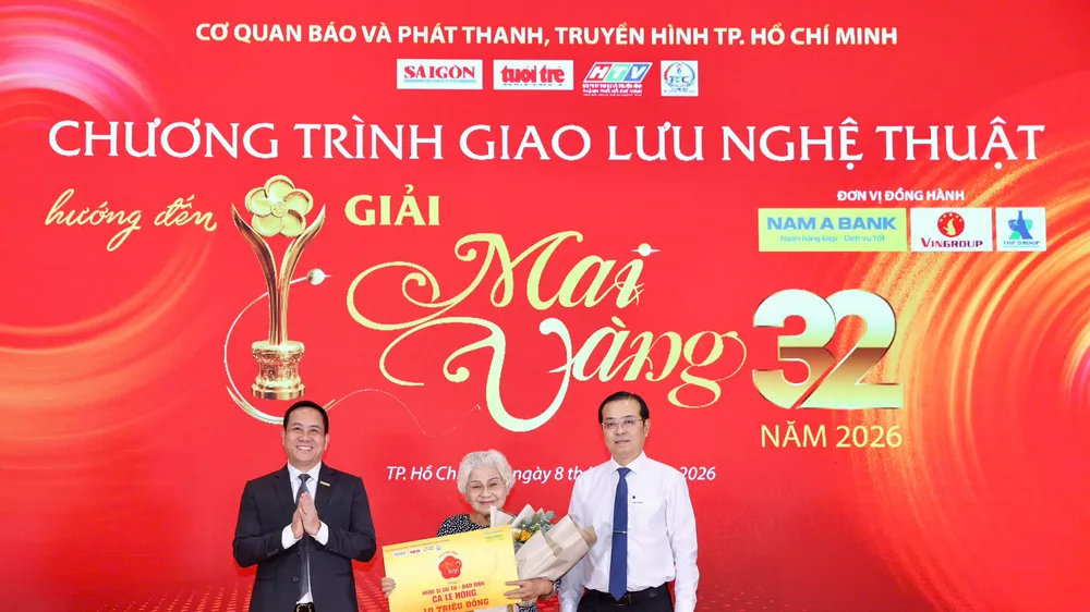 Đồng chí Lê Văn Minh, Thành ủy viên, Tổng Giám đốc Cơ quan Báo và Phát thanh, Truyền hình TP.HCM, Trưởng Ban Chỉ đạo Giải Mai Vàng lần thứ 32 – năm 2026 và ông Hà Huy Cường - Phó Tổng Giám đốc Ngân hàng TMCP Nam Á trao phần thưởng Mai Vàng tri ân cho NSƯT đạo diễn Ca Lê Hồng. Ảnh: HOÀNG TRIỀU