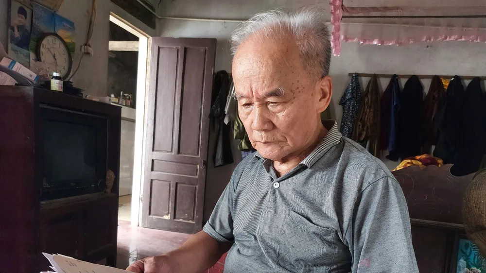 Ông Vương Khả Khai bên tập giấy tờ ghi chép tìm kiếm phần mộ liệt sĩ