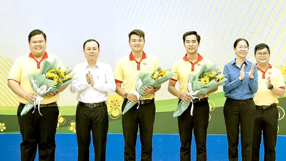 Phó Bí thư Thành ủy TPHCM Nguyễn Văn Hiếu trao hoa cho đội hình ra quân Chiến dịch Xuân tình nguyện 2022. Ảnh: QUỐC THANH