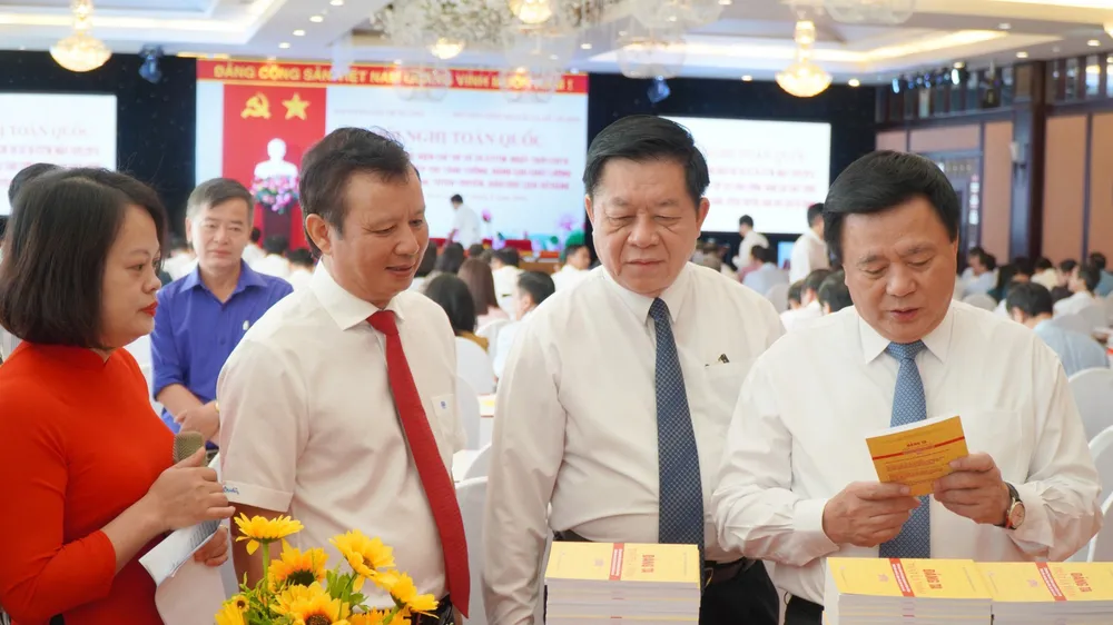 Đồng chí Nguyễn Xuân Thắng và đồng chí Nguyễn Trọng Nghĩa cùng các đại biểu tham quan triển lãm sách về Lịch sử Đảng. Ảnh: VĂN THẮNG