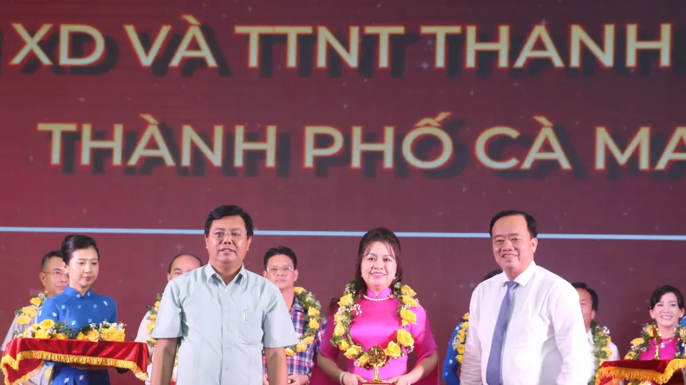 Bí thư Tỉnh ủy Cà Mau Nguyễn Tiến Hải (trái) và Chủ tịch UBND tỉnh Huỳnh Quốc Việt (phải) trao biểu trưng và hoa cho doanh nghiệp tiêu biểu tỉnh Cà Mau năm 2023