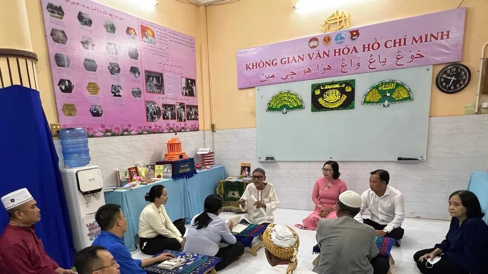 Ông Kariemlos (giữa) giới thiệu đến cộng đồng Chăm theo đạo Hồi về tư liệu, sách ảnh về Bác Hồ tại tiểu Thánh đường Nourl - Ehsan