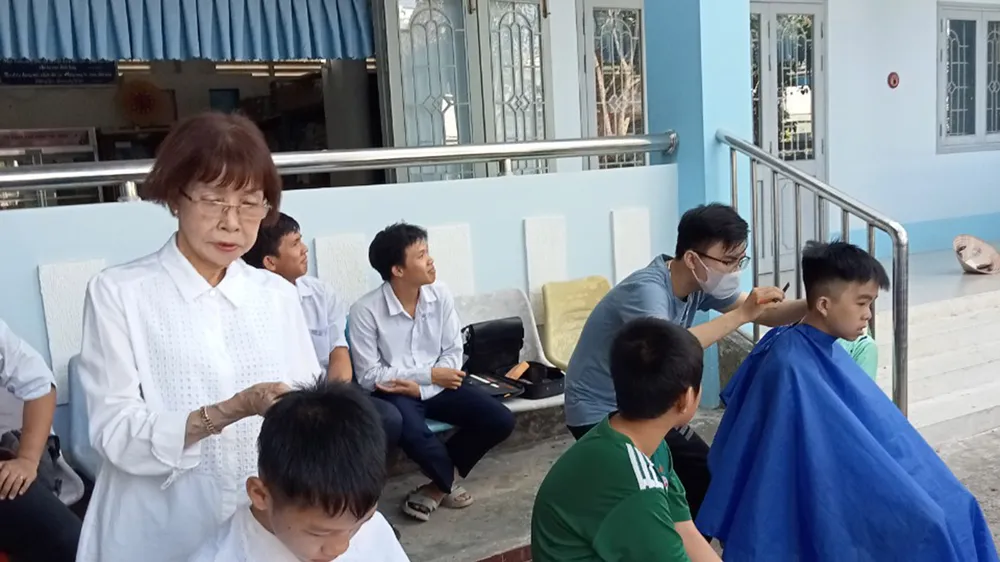 Bà Trần Thị Ánh cắt tóc cho học sinh Trường Nuôi dạy trẻ khuyết tật tỉnh Đồng Tháp