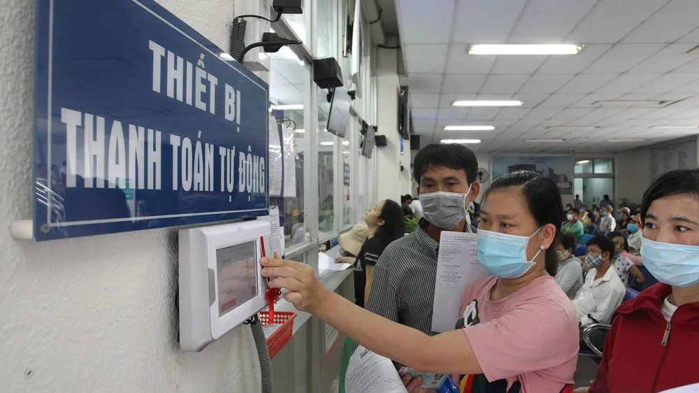 Người dân thanh toán chi phí khám chữa bệnh bằng thẻ thay vì tiền mặt tại BV Chợ Rẫy. Ảnh: HOÀNG HÙNG