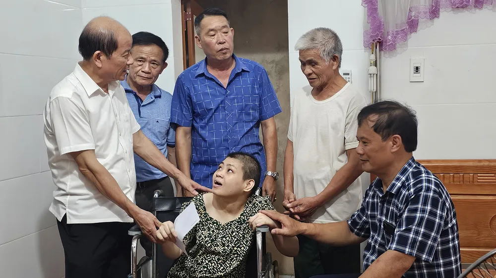 Đại tá Nguyễn Minh Nguyên, Chủ tịch Hội Nạn nhân chất độc da cam/dioxin tỉnh Hà Tĩnh (ngoài cùng bên trái) trao quà cho gia đình ông Nguyễn Đình Thi