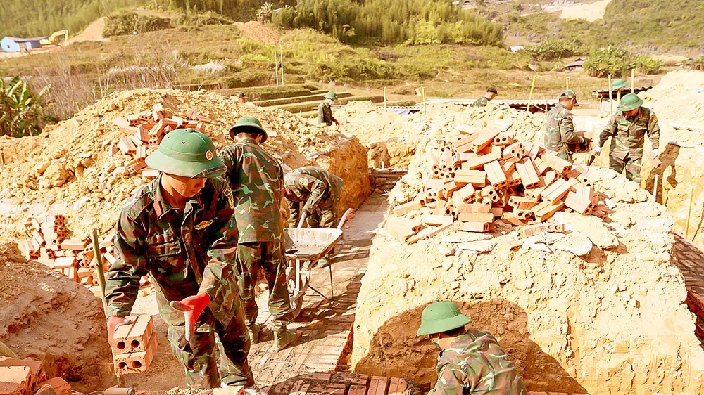 Cán bộ, chiến sĩ Bộ Chỉ huy Quân sự tỉnh Cao Bằng xây nhà tái định cư cho người dân xóm Lũng Cắm. Ảnh: ĐỖ TRUNG
