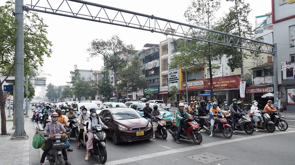 Người tham gia giao thông dừng xe đúng vạch kẻ khi đèn đỏ tại giao lộ Nguyễn Thái Học - Trần Hưng Đạo, quận 1, trưa 8-1. Ảnh: HOÀNG HÙNG
