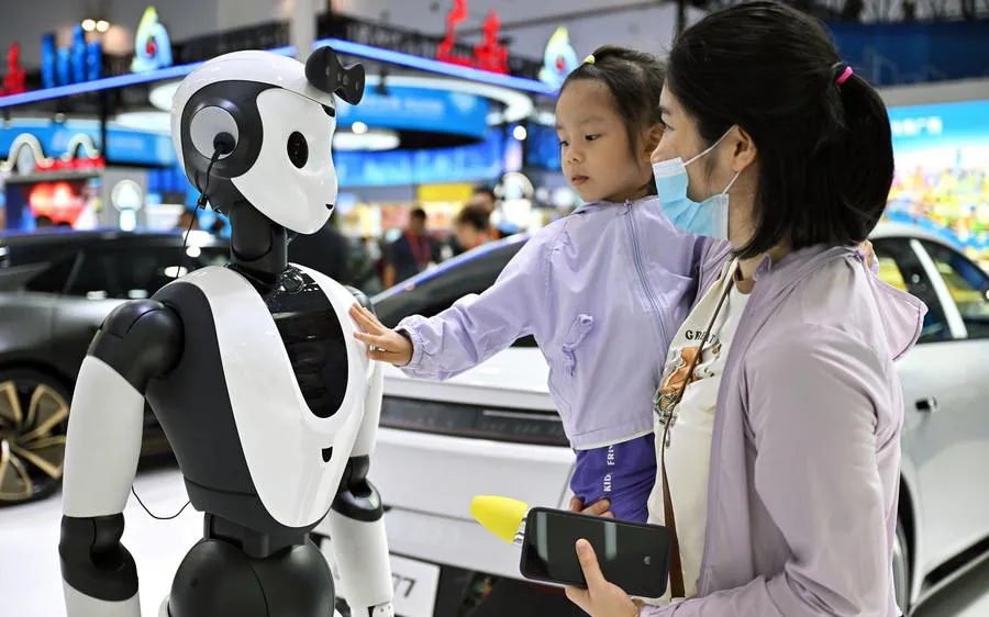 Người dân tương tác robot AI tại Triển lãm tiêu dùng quốc tế Trung Quốc. Ảnh: XINHUA 