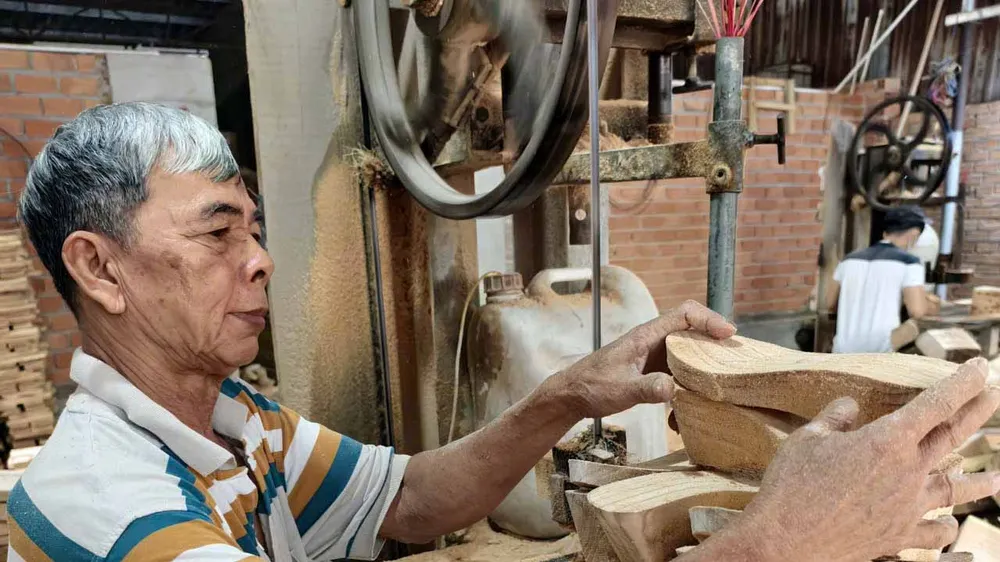  Ông Nguyễn Văn Sụ (64 tuổi) tạo hình những đôi guốc thô 
