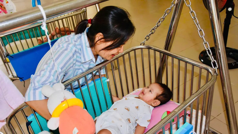 Chị Trần Thị Kim Chi, nhân viên Phòng công tác xã hội và phát triển cộng đồng của Trung tâm Bảo trợ và Công tác xã hội bên các con được nuôi dưỡng tại trung tâm