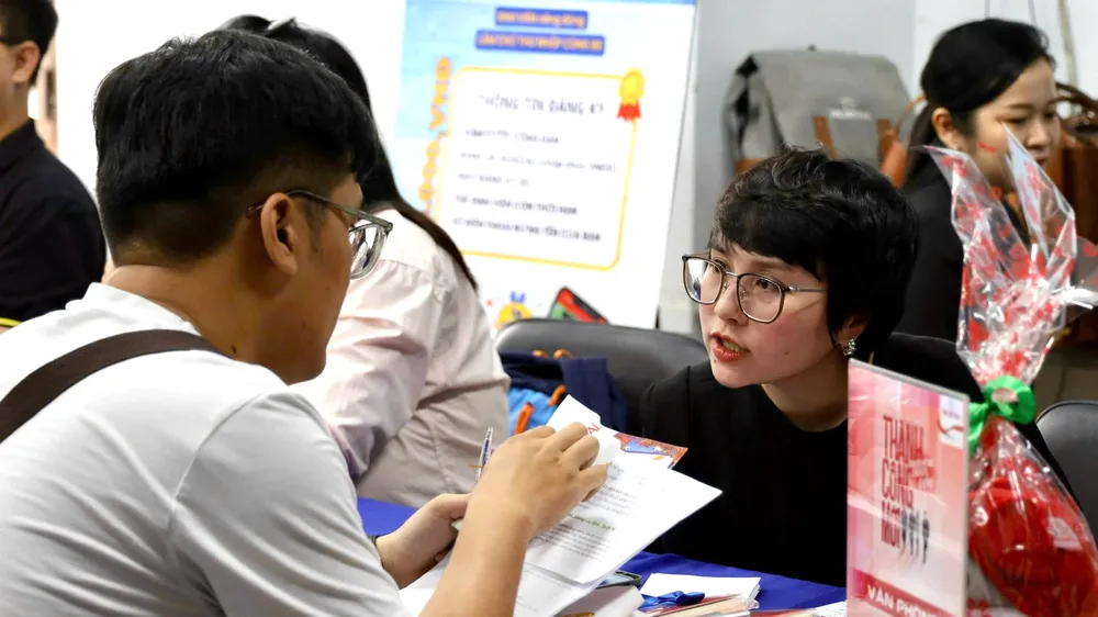 Người lao động tìm hiểu thông tin tuyển dụng tại một ngày hội việc làm được tổ chức ở TPHCM. ẢNH: HUỲNH NHƯ