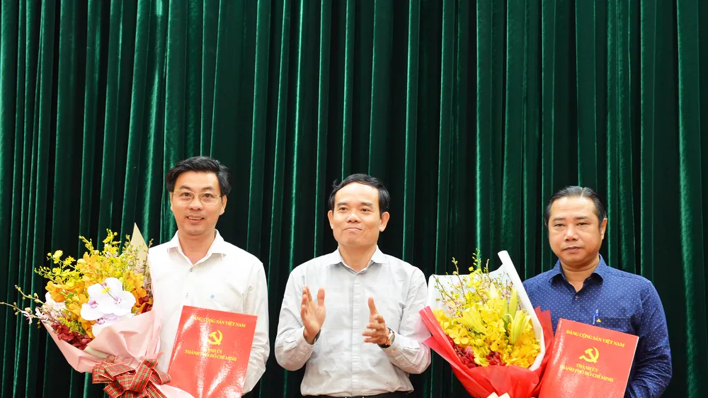 Đồng chí Trần Lưu Quang, Phó Bí thư Thường trực Thành ủy trao quyết định cho đồng chí Nguyễn Anh Tuấn (bên phải) và đồng chí Trần Anh Tuấn (bên trái). Ảnh: VIỆT DŨNG