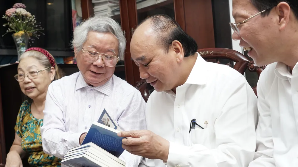 Chủ tịch nước dẫn đầu đoàn tới thăm, chúc mừng nhà báo Dương Trọng Dật. Ảnh: HOÀNG HÙNG