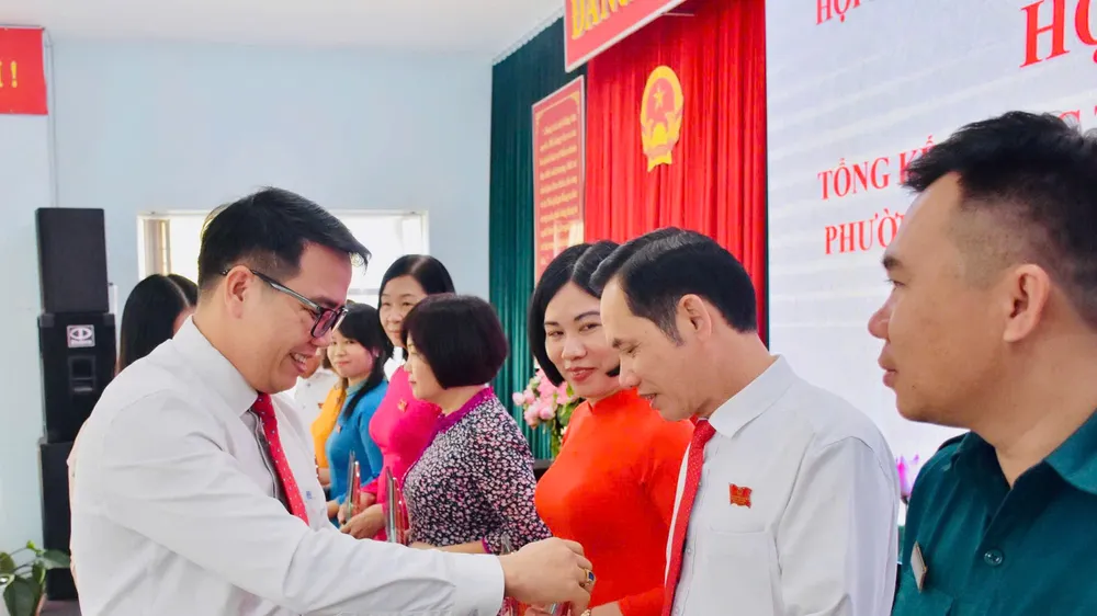 Đồng chí Nguyễn Chí Linh, Phó Bí thư Thường trực Đảng ủy phường Tam Thắng trao quà lưu niệm cho các đại biểu HĐND phường.