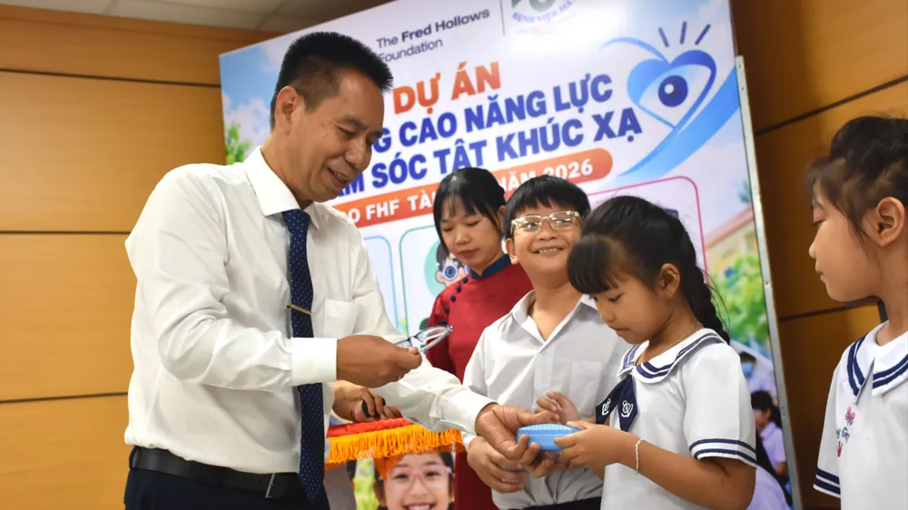 TTND. Nguyễn Viết Giáp trao tặng kính cho các em học sinh.