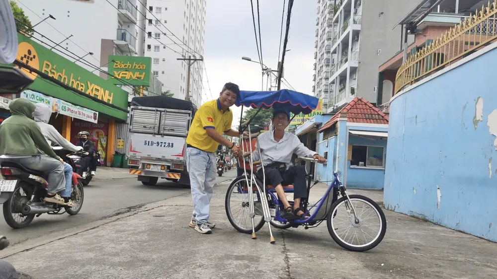 Anh Lê Khắc Dũng, Chủ nhiệm Câu lạc bộ thiện nguyện Vì nụ cười trẻ thơ 72 trao xe lắc tay cho anh Lê Văn Đức
