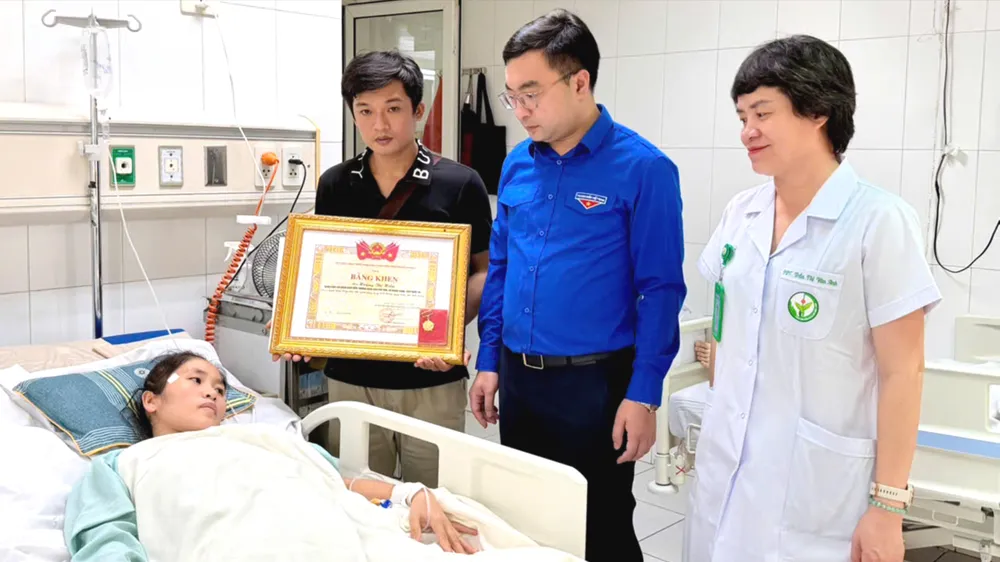 Bí thư Tỉnh đoàn Nghệ An trao bằng khen và Huy hiệu Tuổi trẻ dũng cảm cho cô giáo Hoàng Thị Hiền. Ảnh: Tỉnh đoàn Nghệ An